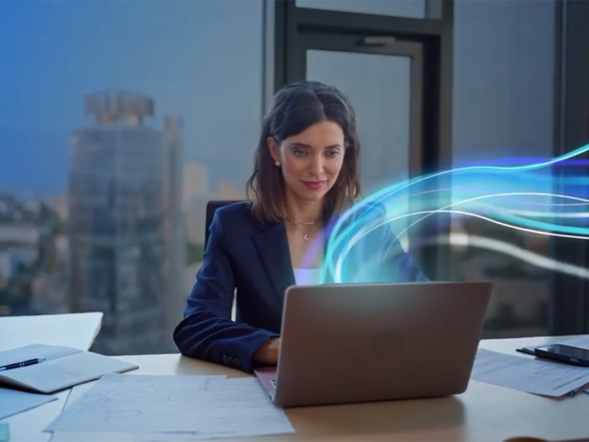 Person working on a laptop at a desk, with abstract blue data lines illustrating secure connectivity.