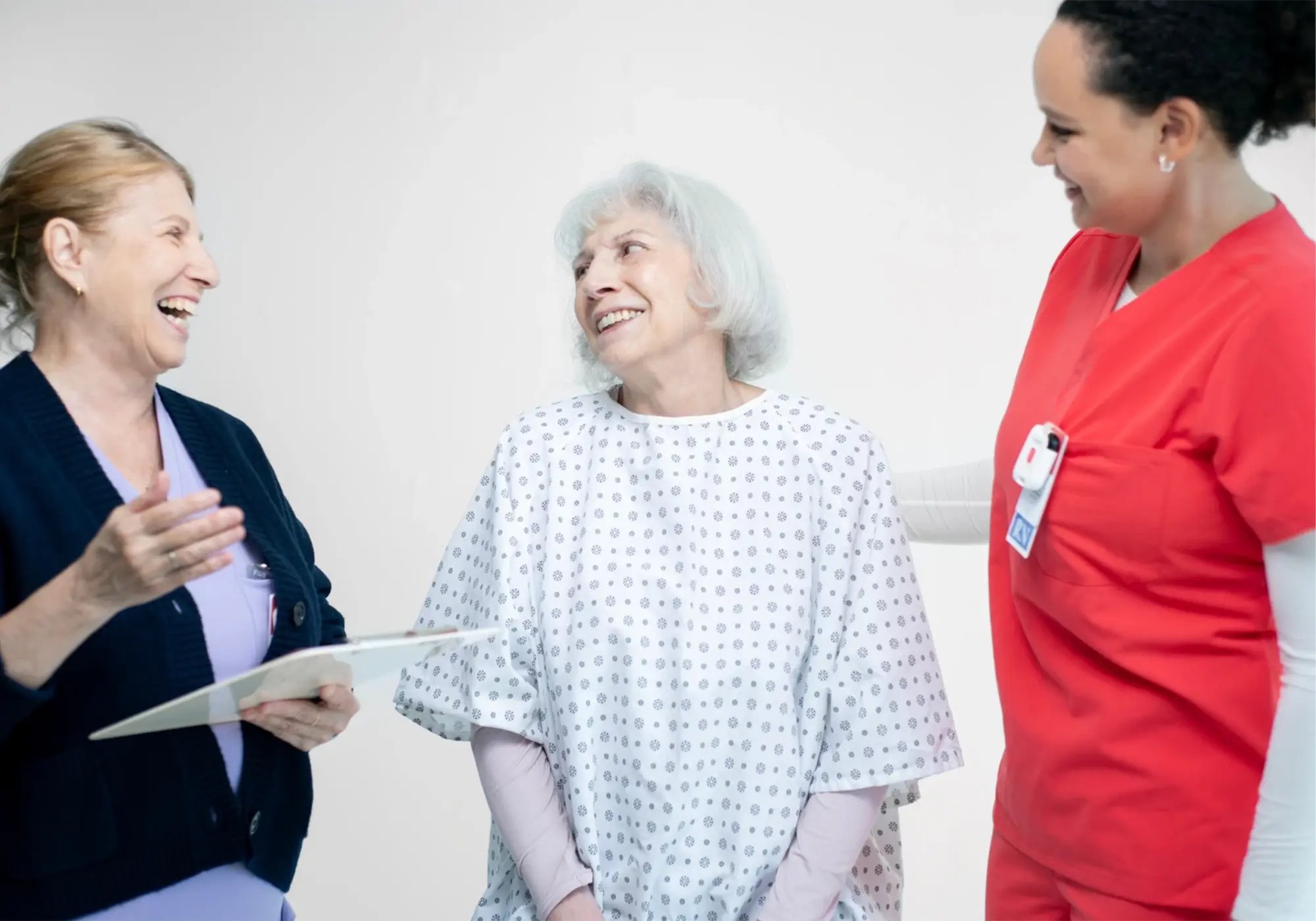 Healthcare staff supporting a patient during a consultation in a medical setting.