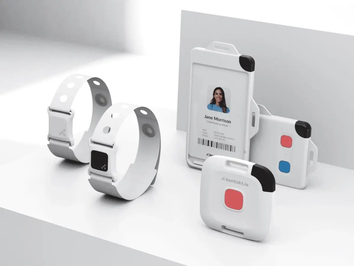 Wearable bands and badge-style IoT devices arranged on a white surface.