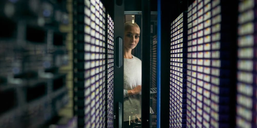 A person looking at a rack of data storage