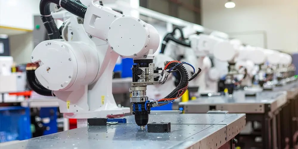 Robotic arms operating along an automated industrial production line.