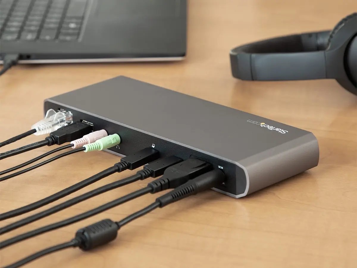 A StarTech docking station on a desk with multiple audio, USB, and network cables plugged in.