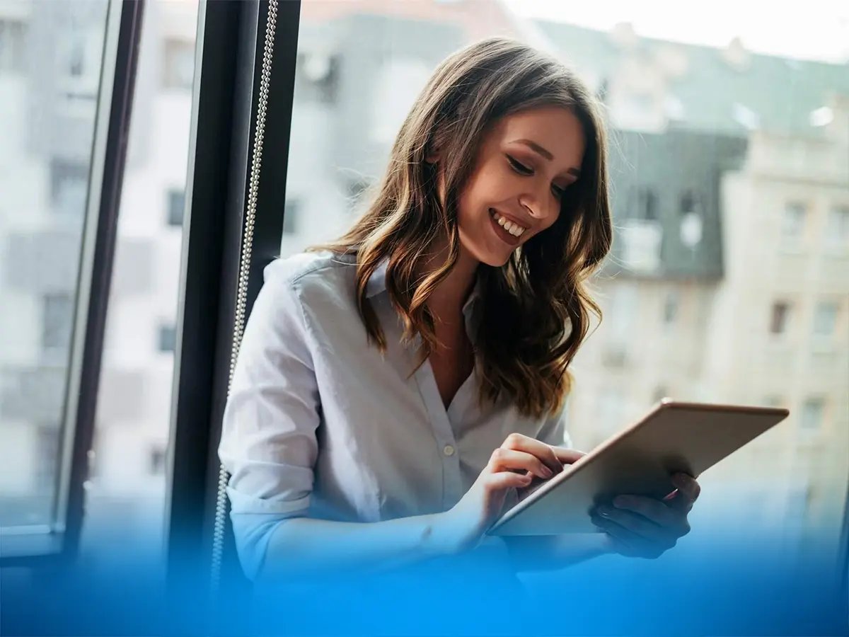 Person standing near a window with city buildings in the background.