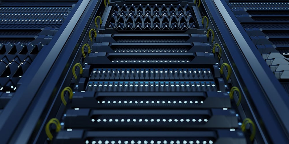 Close-up view of server racks with glowing blue lights and yellow cable loops in a data center.
