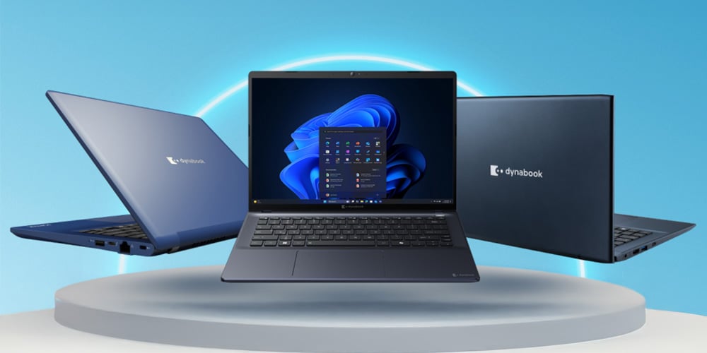 Three business laptops displayed on a platform, one open showing a desktop interface, against a blue studio background.