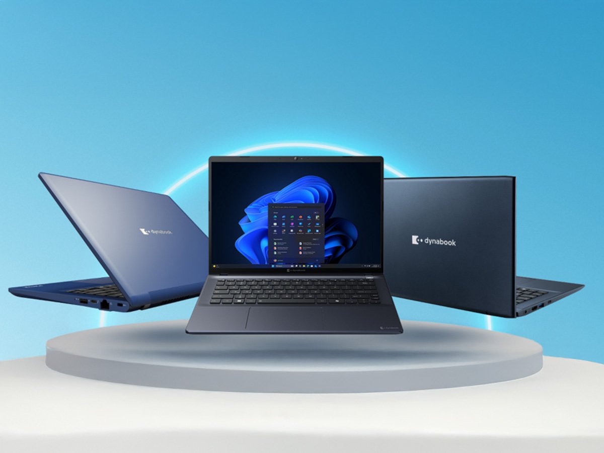 Three business laptops displayed on a platform, one open showing a desktop interface, against a blue studio background.