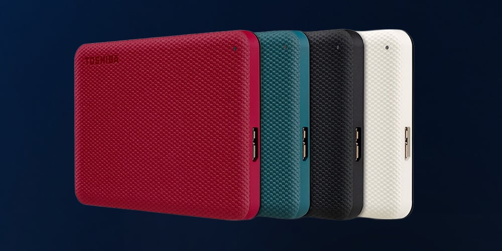 Four compact portable drives in red, teal, black, and white, shown side by side on a dark background.