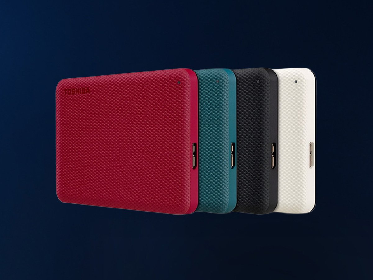 Four compact portable drives in red, teal, black, and white, shown side by side on a dark background.