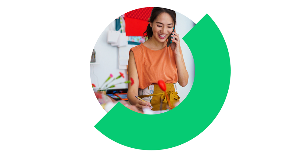 Person taking notes at a workspace, represented within a circular graphic design element.