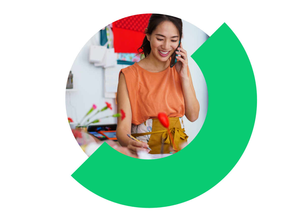 Person taking notes at a workspace, represented within a circular graphic design element.