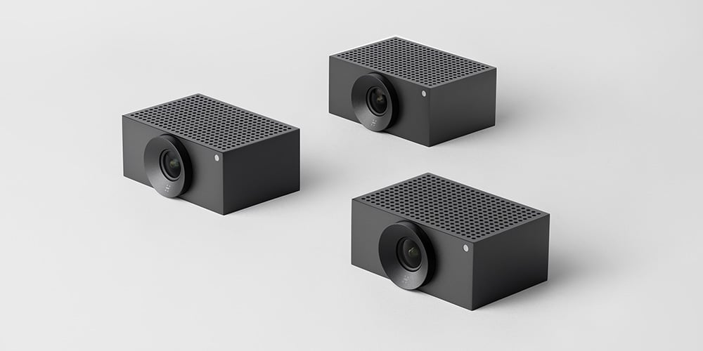 Three compact video conferencing cameras arranged on a light background.