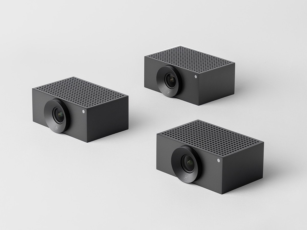 Three compact video conferencing cameras arranged on a light background.