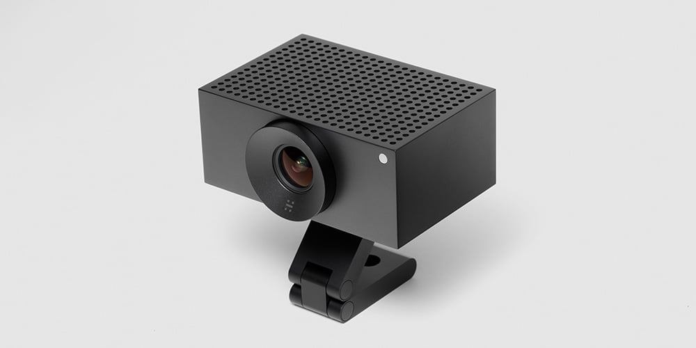 Compact black video conferencing camera on an adjustable stand.