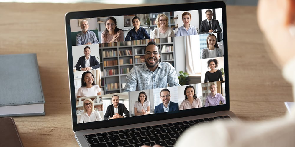 Laptop displaying a grid of participants during a virtual meeting.