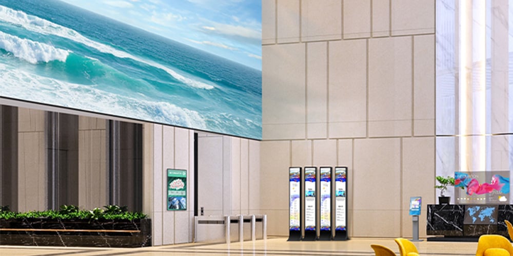 Large digital screen showing ocean waves in a bright modern lobby with information kiosks.