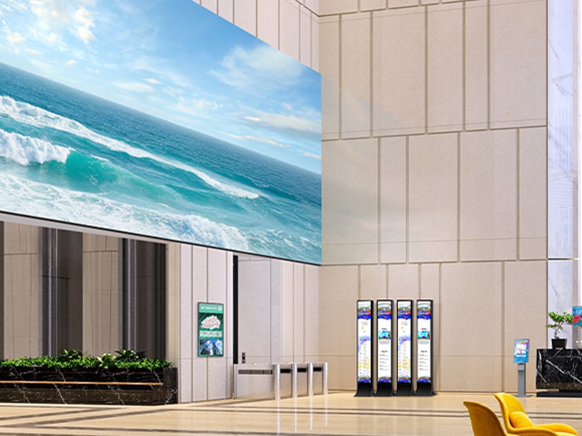 Large digital screen showing ocean waves in a bright modern lobby with information kiosks.