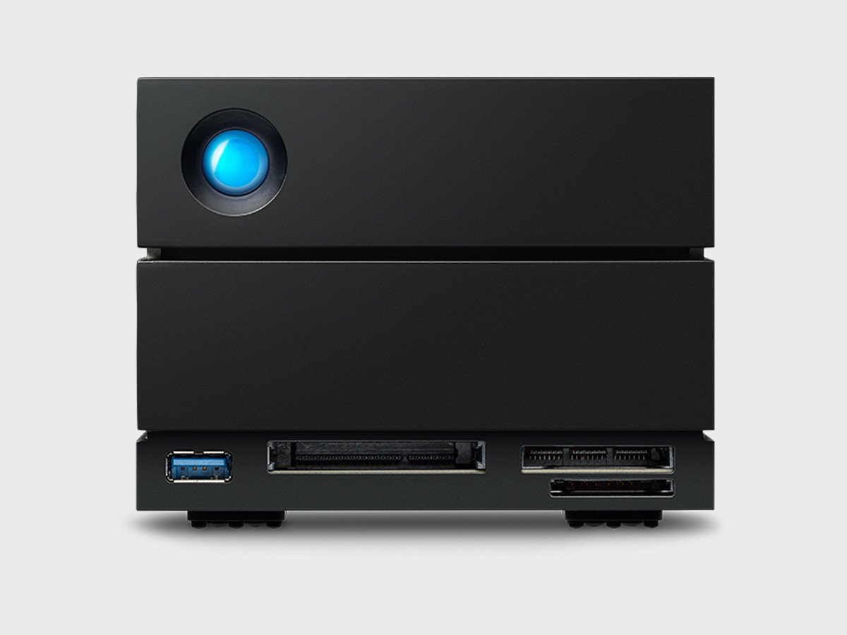 Compact black desktop device with a circular blue indicator and multiple ports on the front.