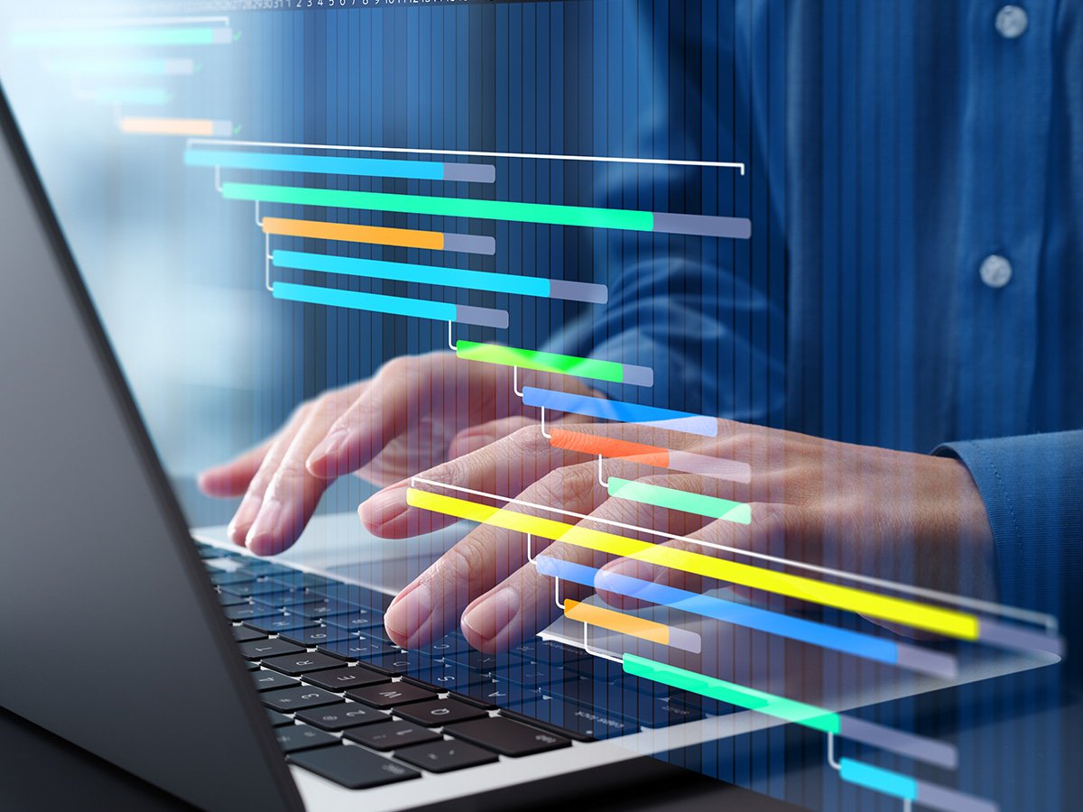 Hands typing on a laptop with colorful horizontal bars overlaid to show software development or project timelines.