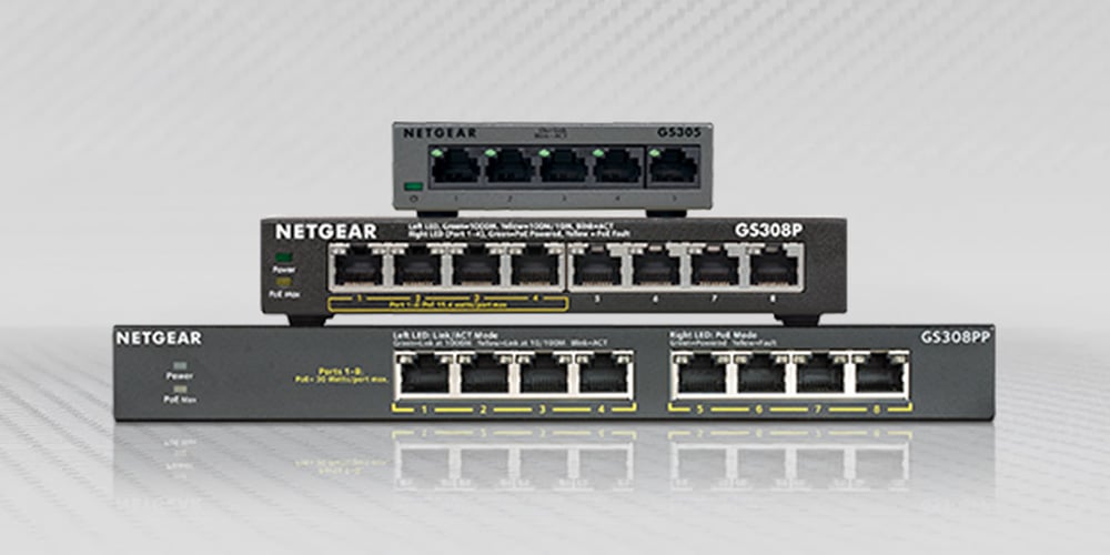 Stack of Netgear network switches with multiple Ethernet ports.