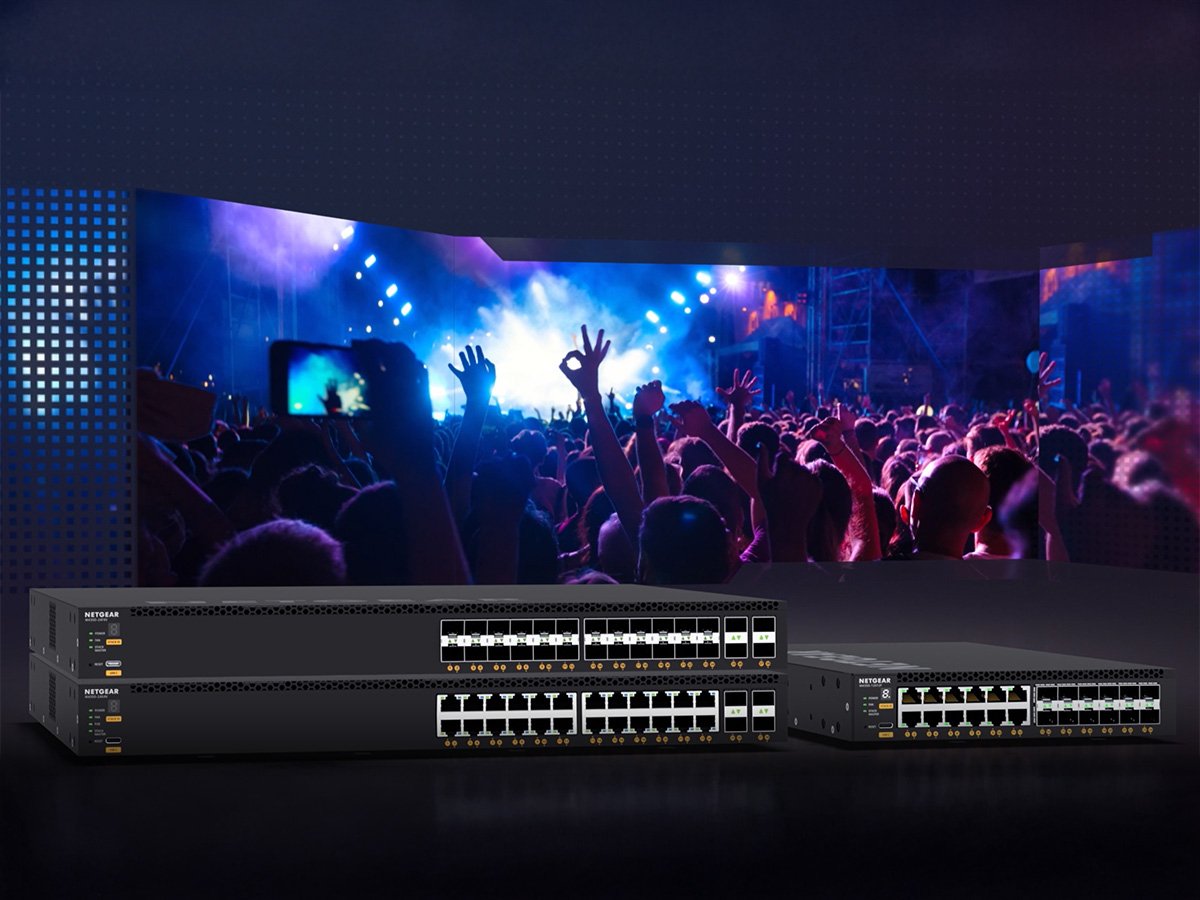 Netgear switches displayed in front of a large concert crowd with colorful lighting.