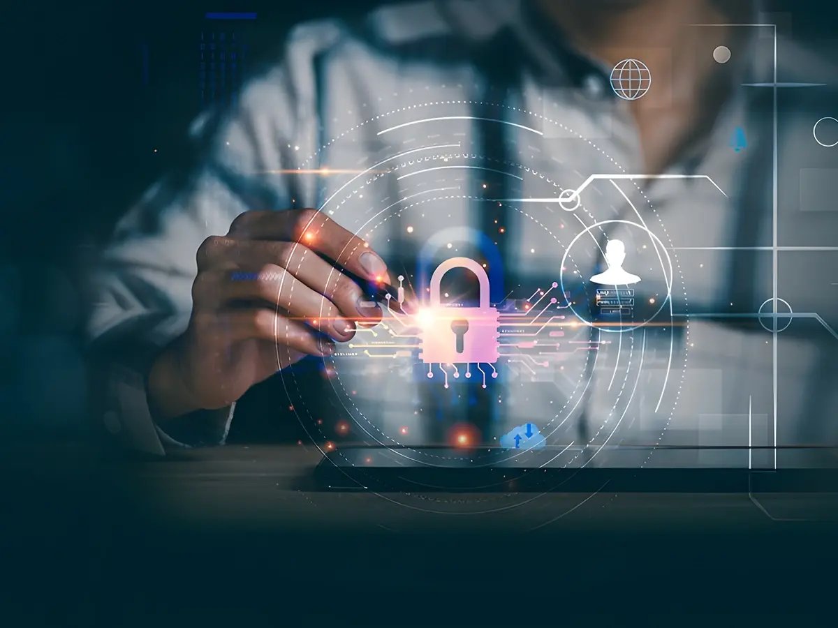 A person in a collared shirt interacting with a digital interface displaying a padlock symbol, representing cybersecurity and data protection. Background includes abstract technological icons and graphics.