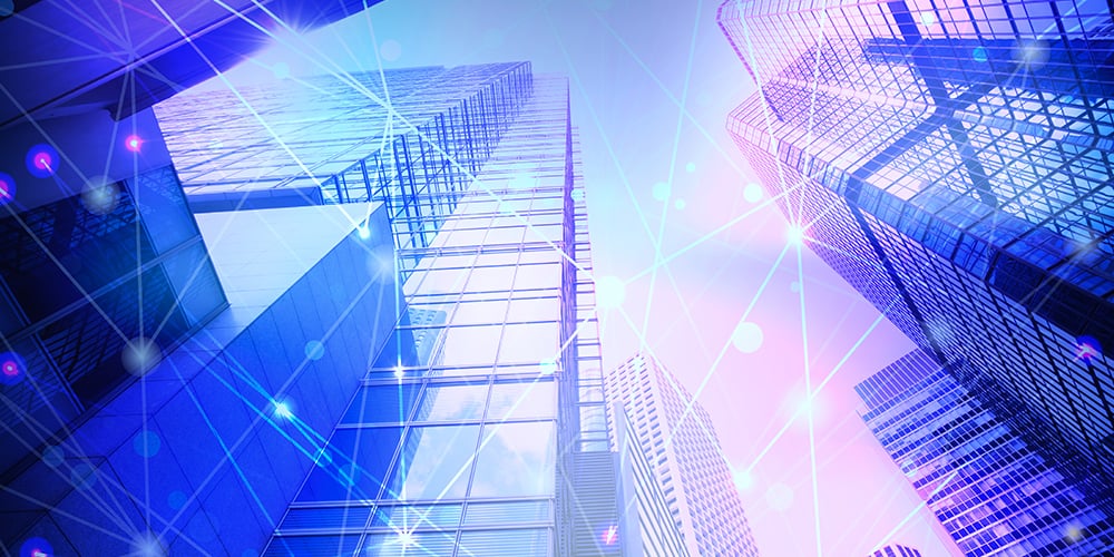 View of tall glass skyscrapers connected by glowing network lines, symbolizing digital connectivity.