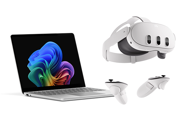 Laptop next to a VR headset with two handheld controllers.