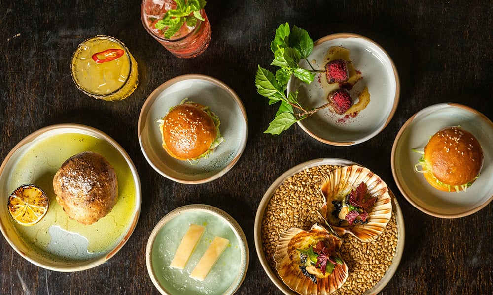 Overhead view of gourmet dishes and drinks on a table.