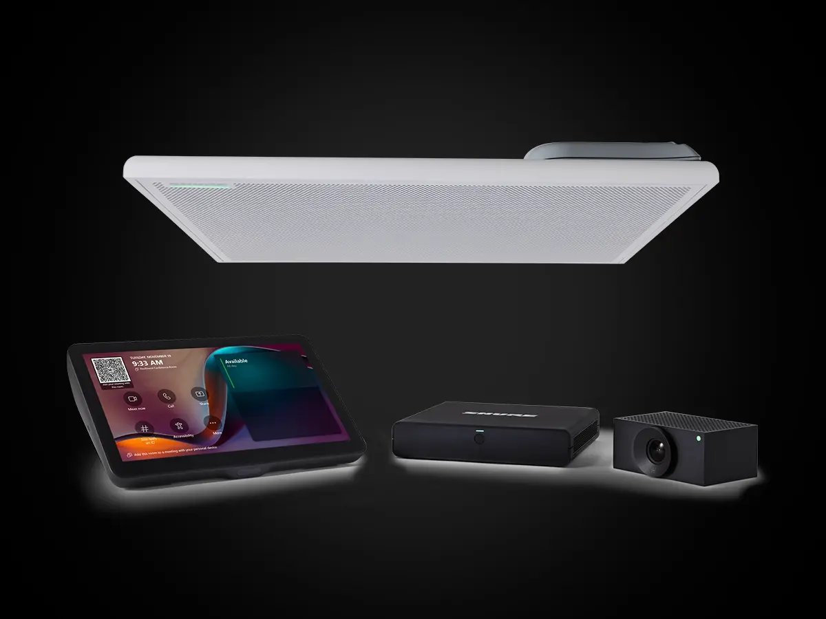 Shure conferencing equipment displayed on a dark background, including a ceiling microphone, touch controller, camera, and processing unit.