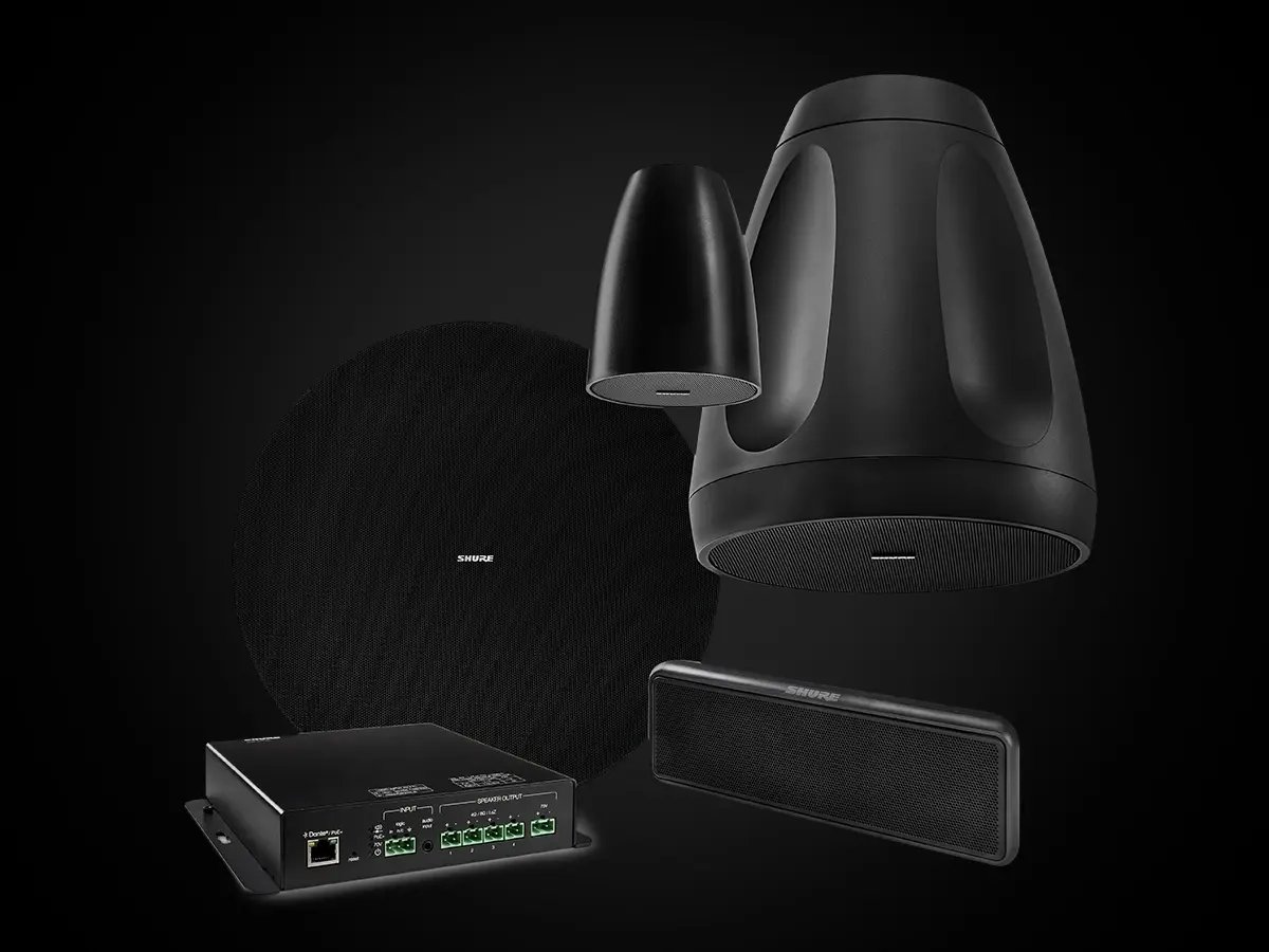 Shure loudspeaker system components arranged on a dark background, including ceiling, pendant, wall-mounted, and amplifier units.