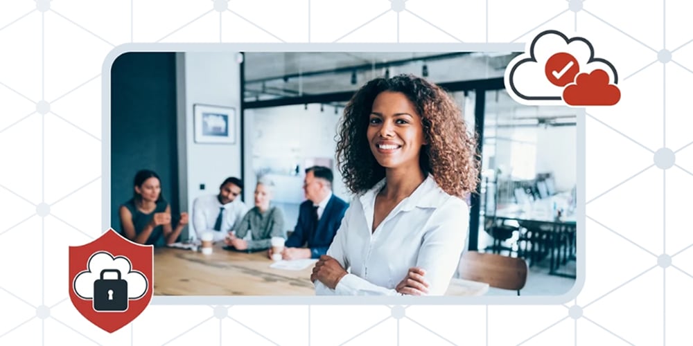 Person standing confidently in front of a meeting table with colleagues seated in the background, with security icons overlaid.