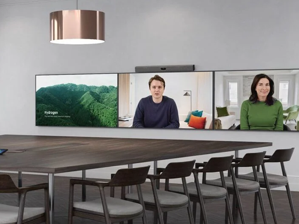 Large meetingroom with 3 Displays side by side set up for a video call with two people