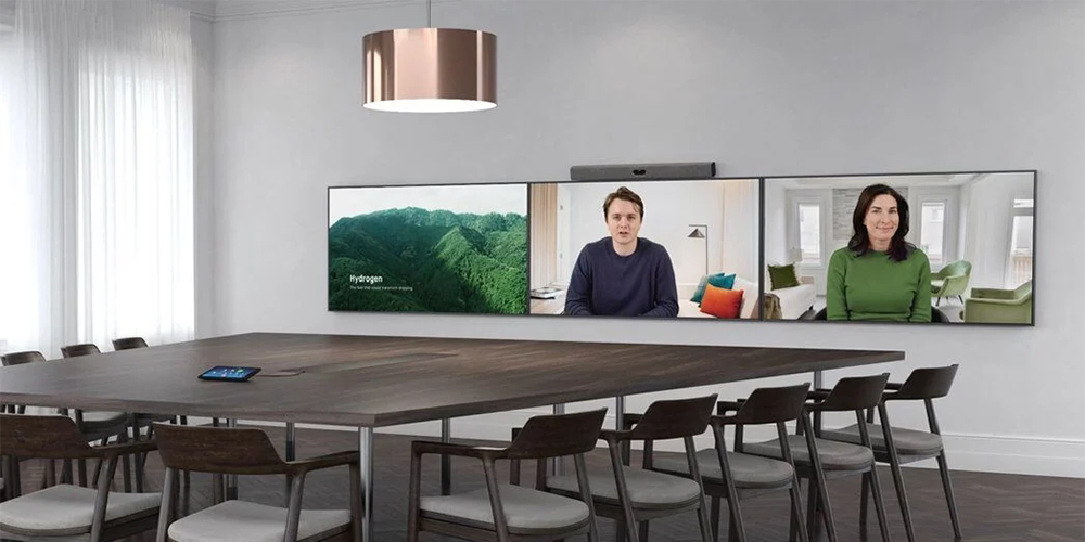 Large meetingroom with 3 Displays side by side set up for a video call with two people