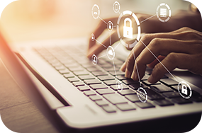 Hands typing on a laptop keyboard with security icons overlayed.